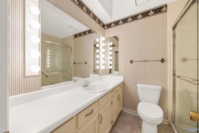 bathroom with tile patterned flooring, a shower with door, vanity, and toilet