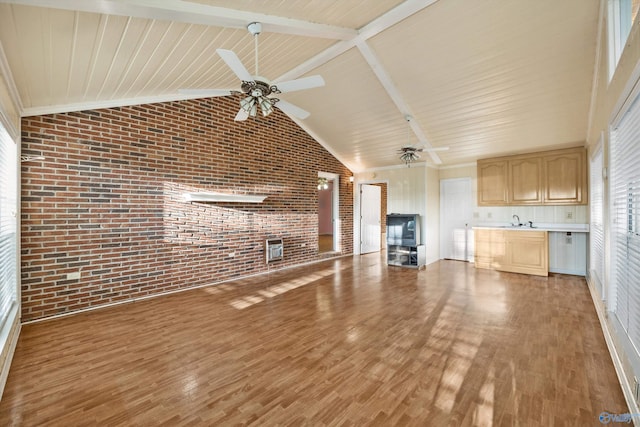 unfurnished living room with beamed ceiling, sink, brick wall, high vaulted ceiling, and hardwood / wood-style floors