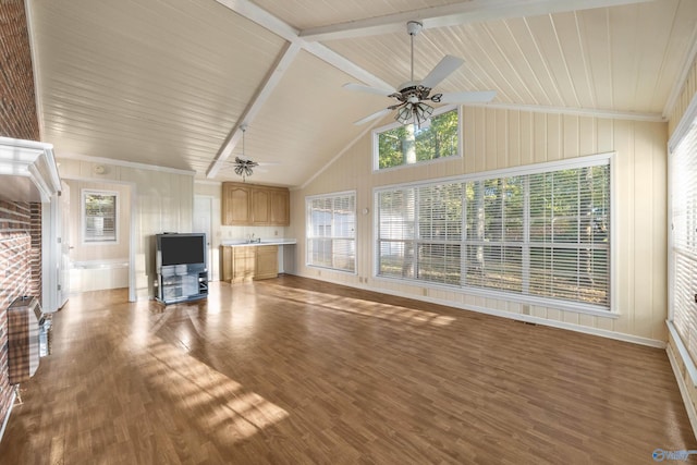 unfurnished living room featuring lofted ceiling with beams, wooden walls, ceiling fan, and hardwood / wood-style floors