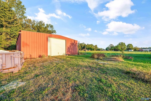 view of yard with a garage and an outbuilding