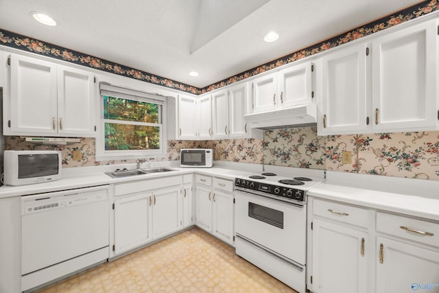 kitchen with white appliances, white cabinets, and sink