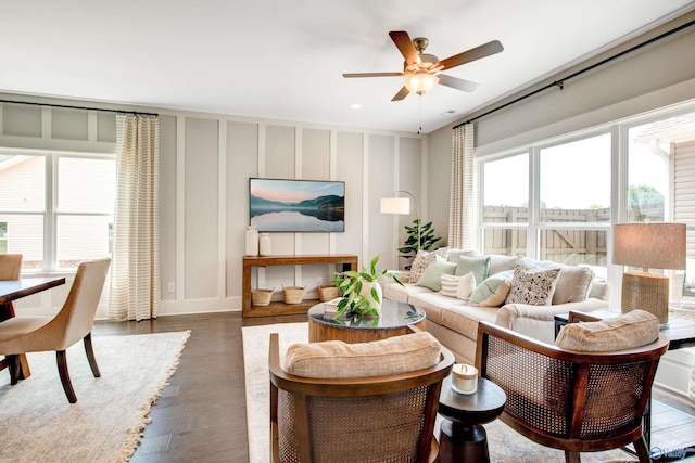 living area featuring dark wood-style floors, recessed lighting, a ceiling fan, and a decorative wall