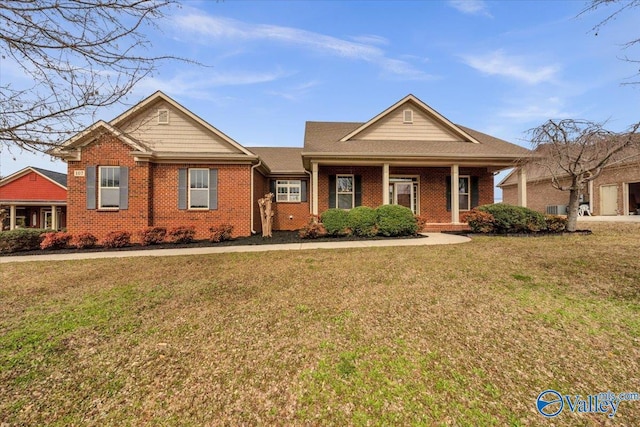 view of front of home with a porch, brick siding, and a front lawn