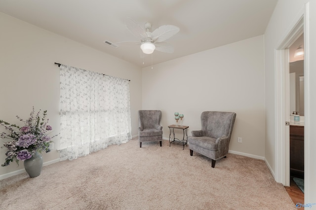 living area featuring ceiling fan and light colored carpet