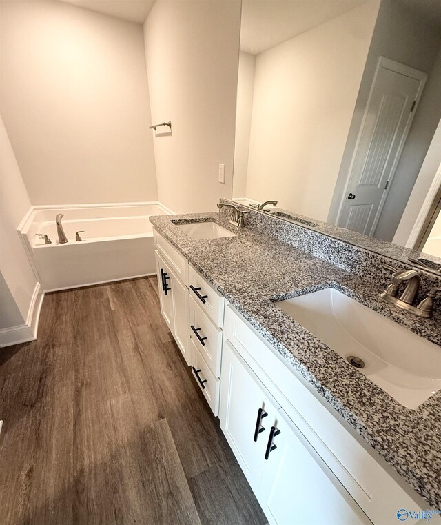 301 Carnation Ave, Meridianville, AL 35759 - bathroom with double vanity, a sink, and wood finished floors