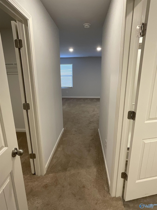 hall featuring dark colored carpet