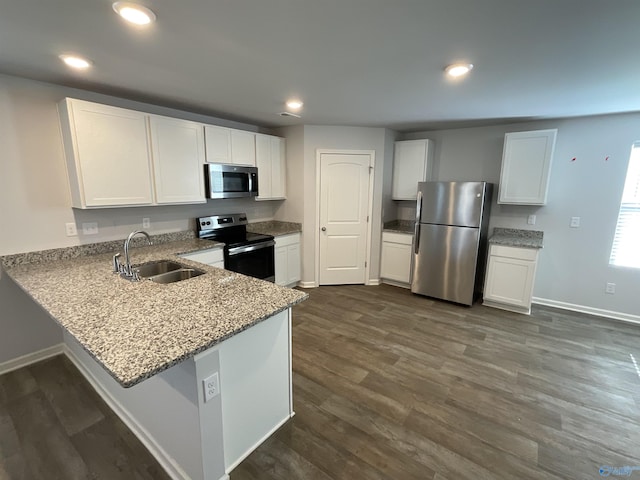 kitchen featuring kitchen peninsula, sink, white cabinetry, dark wood-type flooring, and appliances with stainless steel finishes