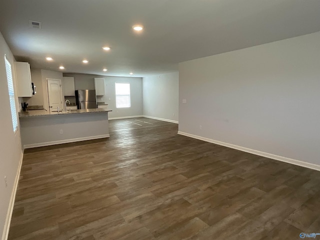 unfurnished living room featuring dark hardwood / wood-style floors and sink