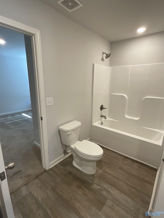 bathroom with toilet, bathtub / shower combination, and hardwood / wood-style floors