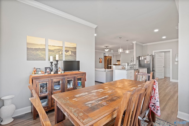 dining area featuring ceiling fan, light hardwood / wood-style floors, and ornamental molding