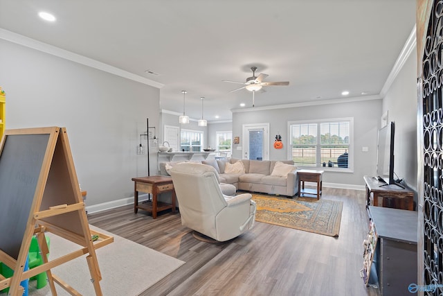 living room with hardwood / wood-style floors, ceiling fan, and ornamental molding