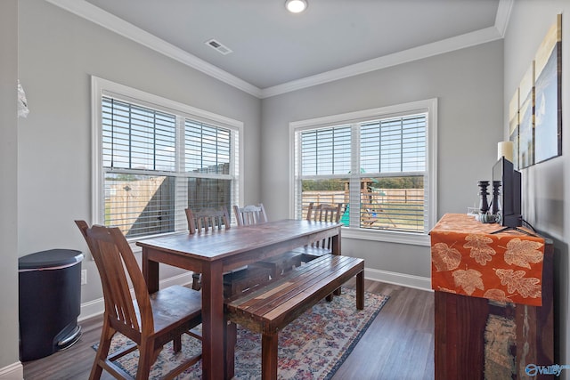 dining area featuring dark wood-type flooring and ornamental molding