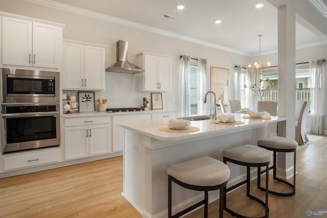106 Kite Cir, Madison, AL 35756 - kitchen with appliances with stainless steel finishes, wall chimney range hood, plenty of natural light, white cabinetry, and crown molding