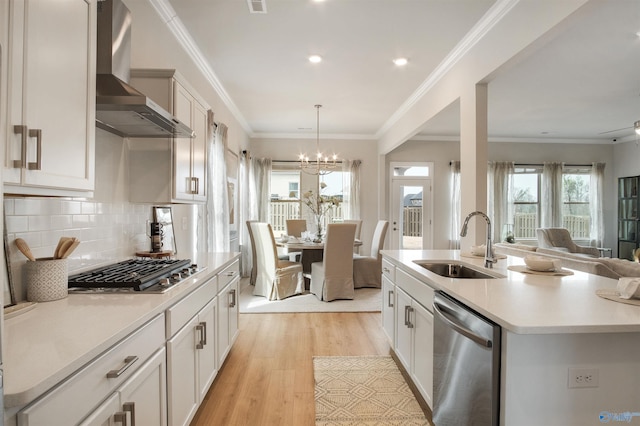 106 Kite Cir, Madison, AL 35756 - kitchen with stainless steel appliances, wall chimney range hood, light countertops, open floor plan, and light wood-style floors