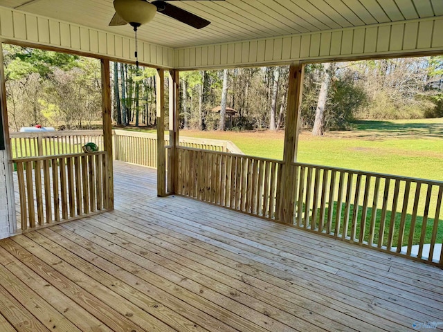 wooden deck with a lawn and a ceiling fan