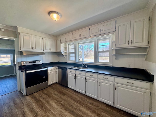 kitchen featuring stainless steel appliances, dark countertops, a sink, and under cabinet range hood