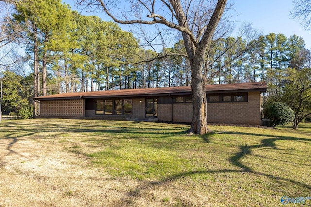 view of front facade featuring brick siding and a front yard