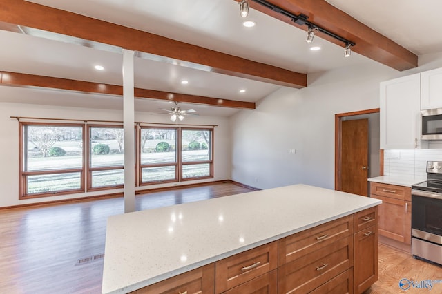 kitchen featuring light stone countertops, beam ceiling, decorative backsplash, appliances with stainless steel finishes, and light wood-type flooring