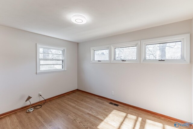 unfurnished room with visible vents, baseboards, and light wood-style floors