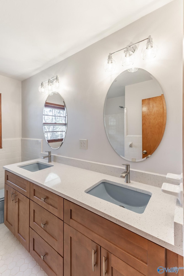 full bathroom with double vanity, tile patterned flooring, and a sink