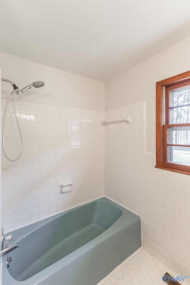 bathroom featuring tile patterned flooring, tile walls, and shower / tub combination