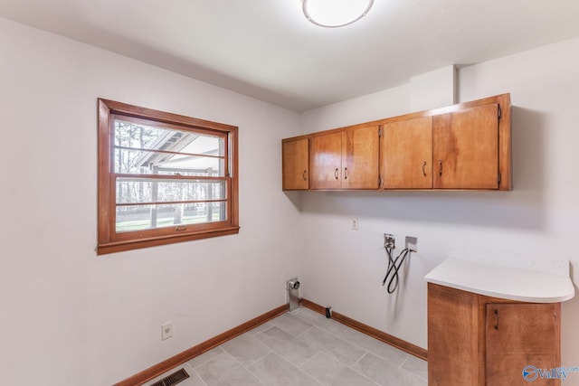 laundry room with hookup for a washing machine, cabinet space, baseboards, and visible vents