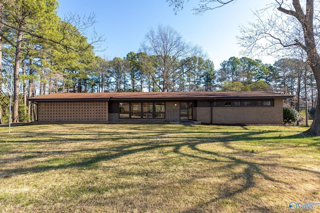 back of house featuring a yard and brick siding