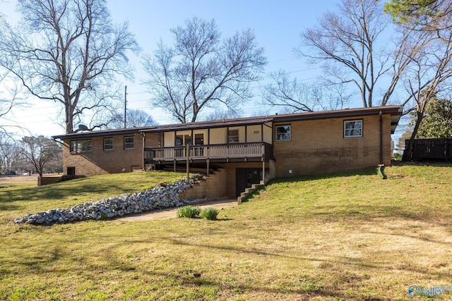 back of property with stairway, a lawn, a deck, and brick siding