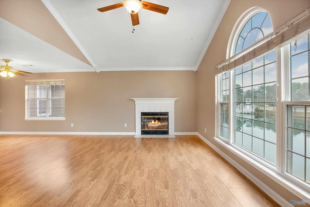 unfurnished living room featuring vaulted ceiling, light hardwood / wood-style floors, and a tile fireplace