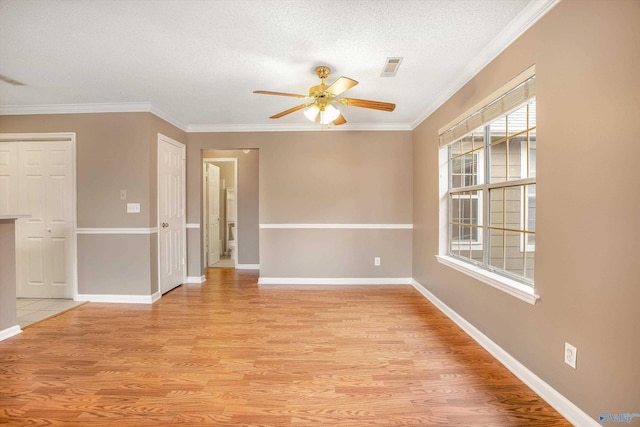 unfurnished room with crown molding, ceiling fan, a textured ceiling, and light wood-type flooring