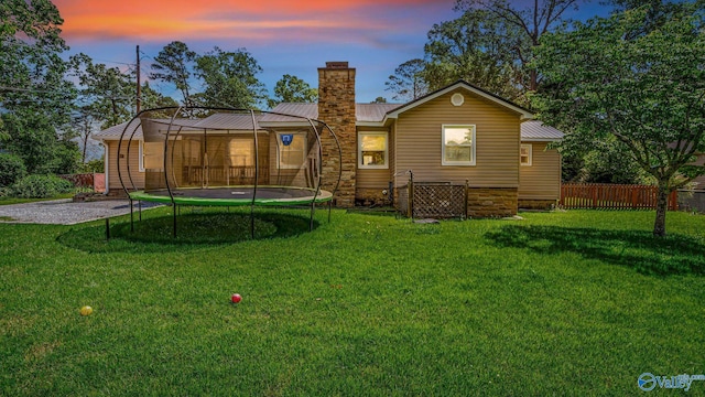 111 Althea St, Gadsden, AL 35904 - back of property at dusk featuring a trampoline, a chimney, and metal roof