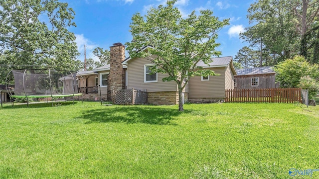 111 Althea St, Gadsden, AL 35904 - back of house with a trampoline, a lawn, and a chimney