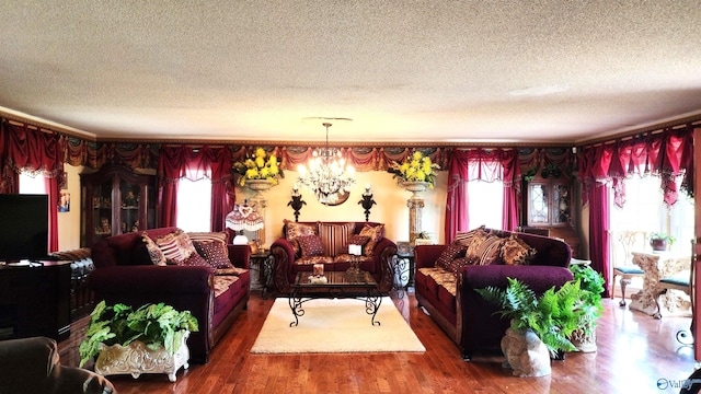 living room with hardwood / wood-style floors, a notable chandelier, and a textured ceiling