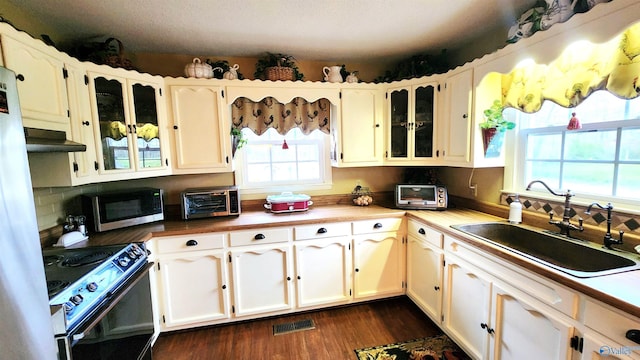 kitchen featuring white cabinetry, sink, electric range oven, dark hardwood / wood-style floors, and decorative backsplash