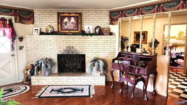 living room featuring crown molding, wood-type flooring, and a textured ceiling