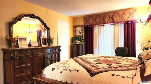 bedroom featuring a textured ceiling and an inviting chandelier