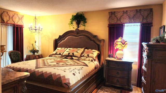 bedroom featuring a notable chandelier and a textured ceiling