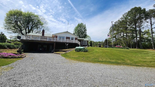 view of front facade with a deck and a front lawn