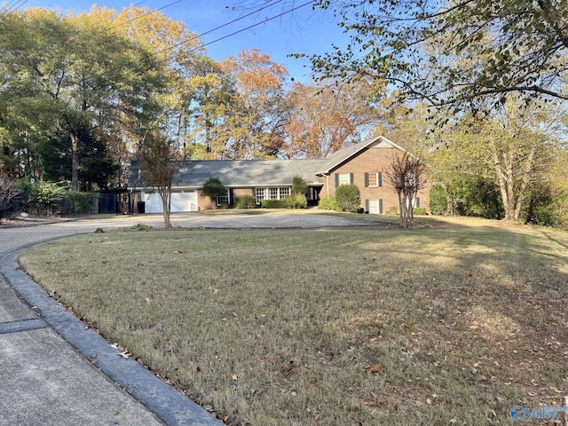 ranch-style house with a garage and a front lawn