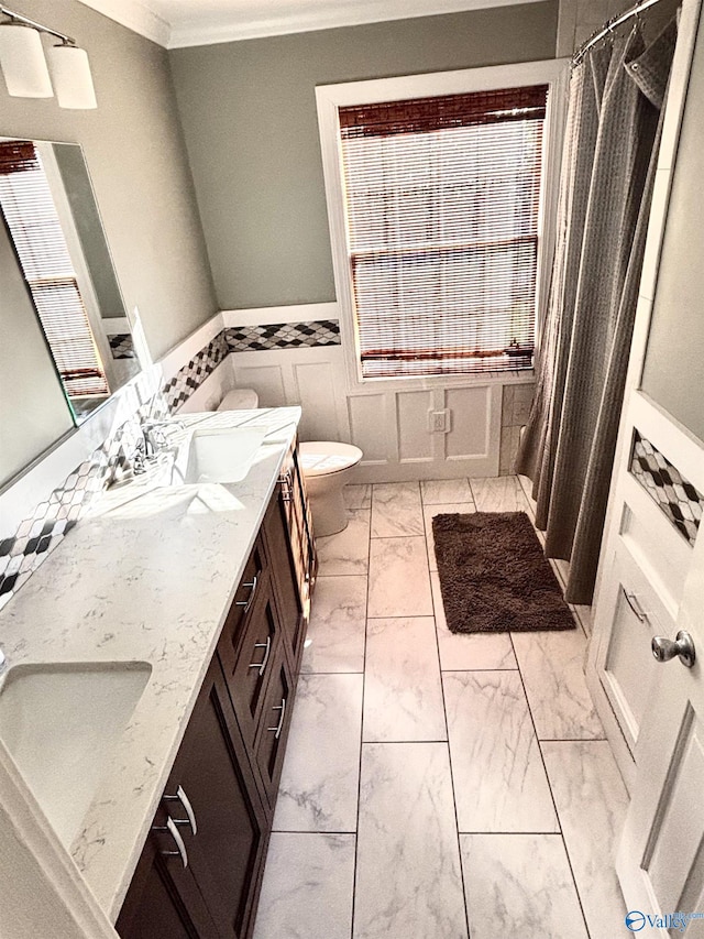 bathroom with vanity, toilet, and crown molding