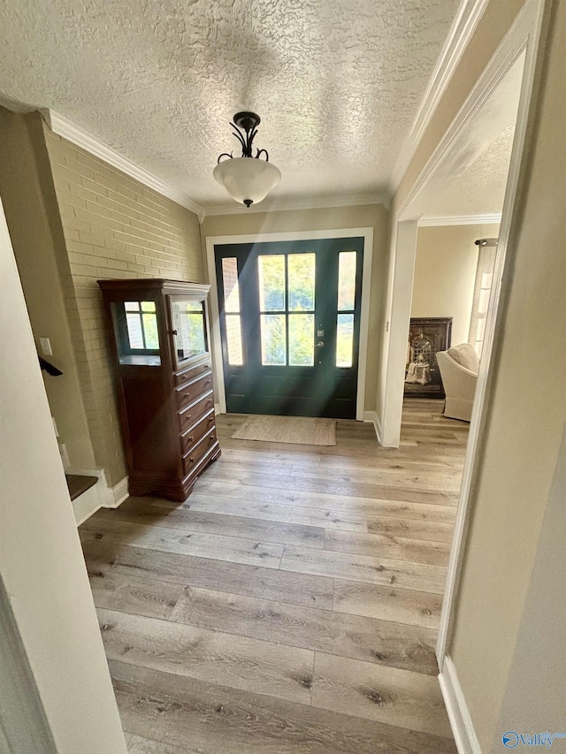 entryway with crown molding, hardwood / wood-style floors, and a textured ceiling