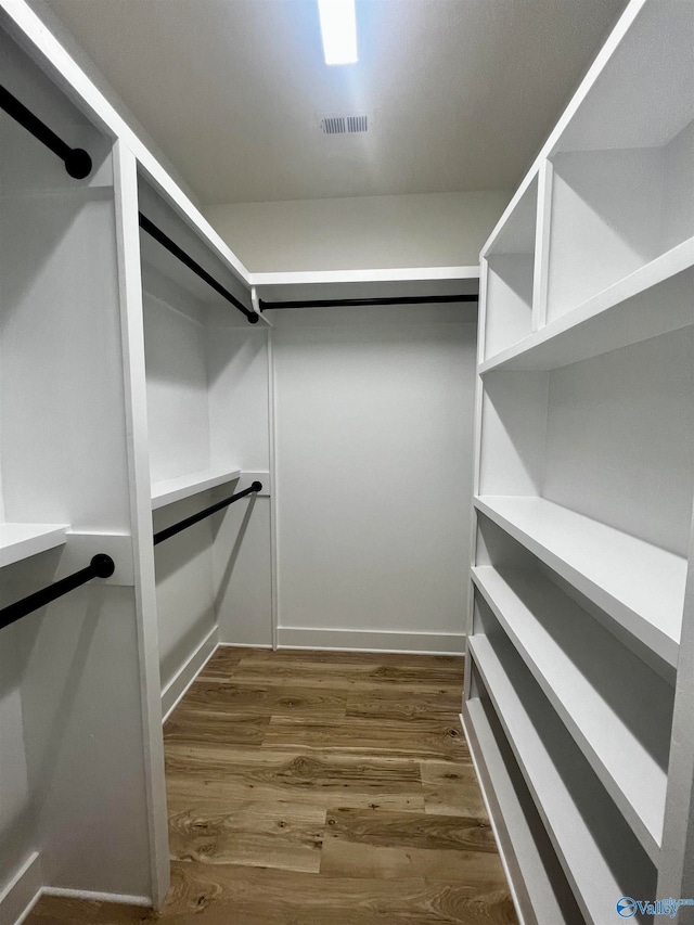 spacious closet featuring dark hardwood / wood-style floors