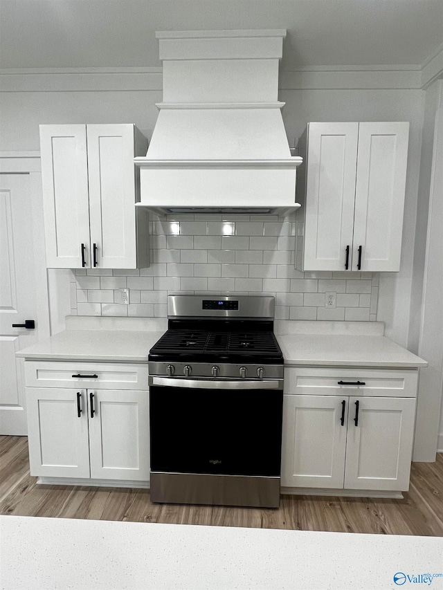 kitchen featuring gas range, white cabinets, and light hardwood / wood-style floors