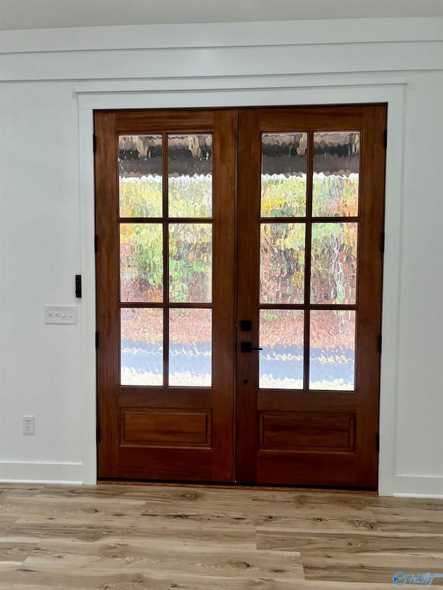 doorway to outside with light hardwood / wood-style floors, french doors, and a healthy amount of sunlight