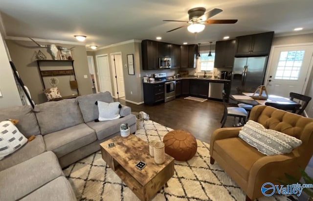 living area with ceiling fan, recessed lighting, dark wood-type flooring, baseboards, and crown molding