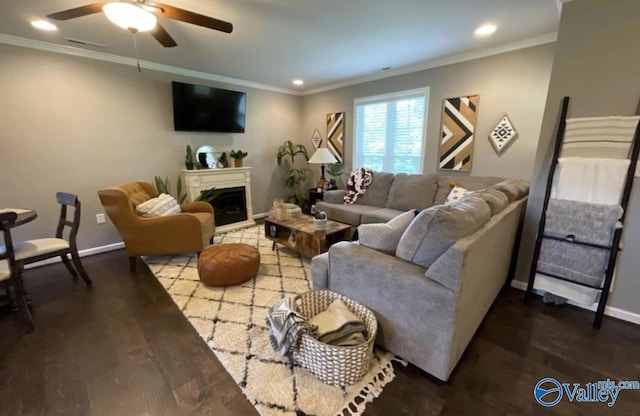 living area featuring ornamental molding, a fireplace, baseboards, and wood finished floors