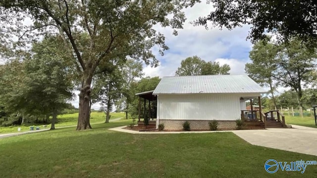 view of home's exterior with metal roof, a lawn, and brick siding