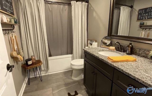 bathroom with shower / bathtub combination with curtain, vanity, and toilet