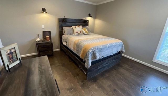 bedroom featuring baseboards, wood finished floors, and ornamental molding