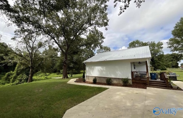 back of house featuring metal roof, a yard, brick siding, and a porch